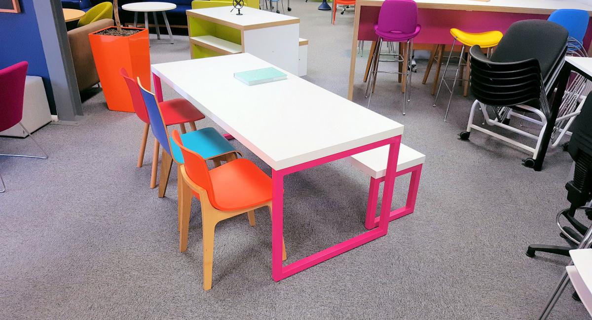 Pink framed loop end bench table with polypropylene stools and chairs for the education dining environment.
