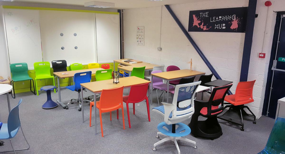 Interactive white board teacher wall unit finished in white and lime green, with complimentary classroom tables,  chairs and breakout furniture.