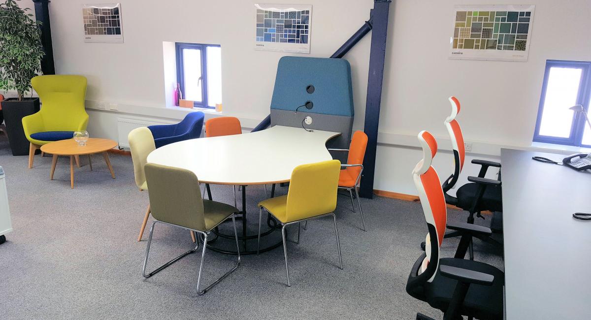 Office pod with blue screen and white table top.  