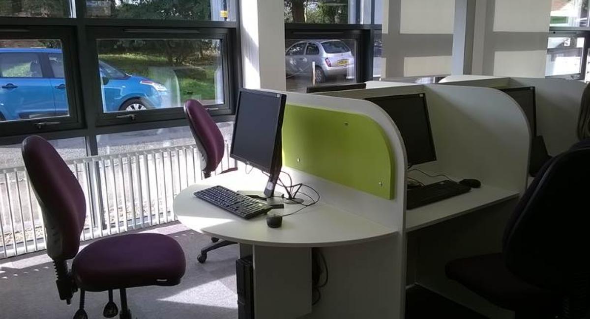 Library refurbishment white study furniture desks with green screens and operator chairs 