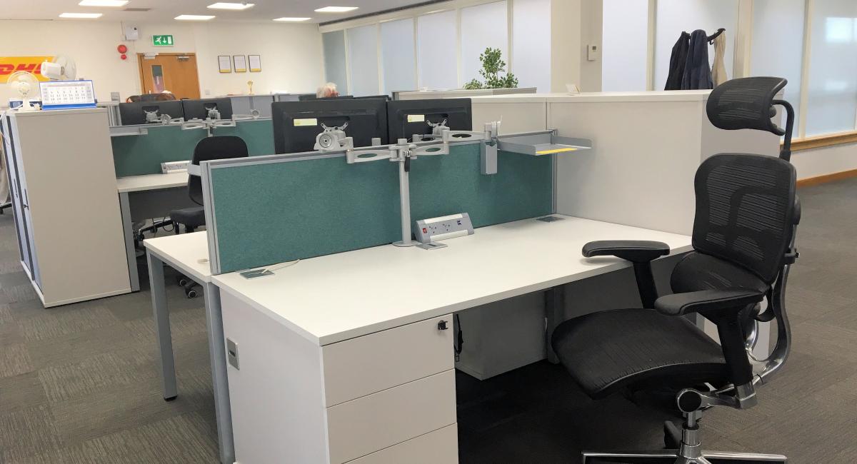 White cantilver frame office desk, partnered with white personal pedestal drawers and black task chairs with headrest and arms.