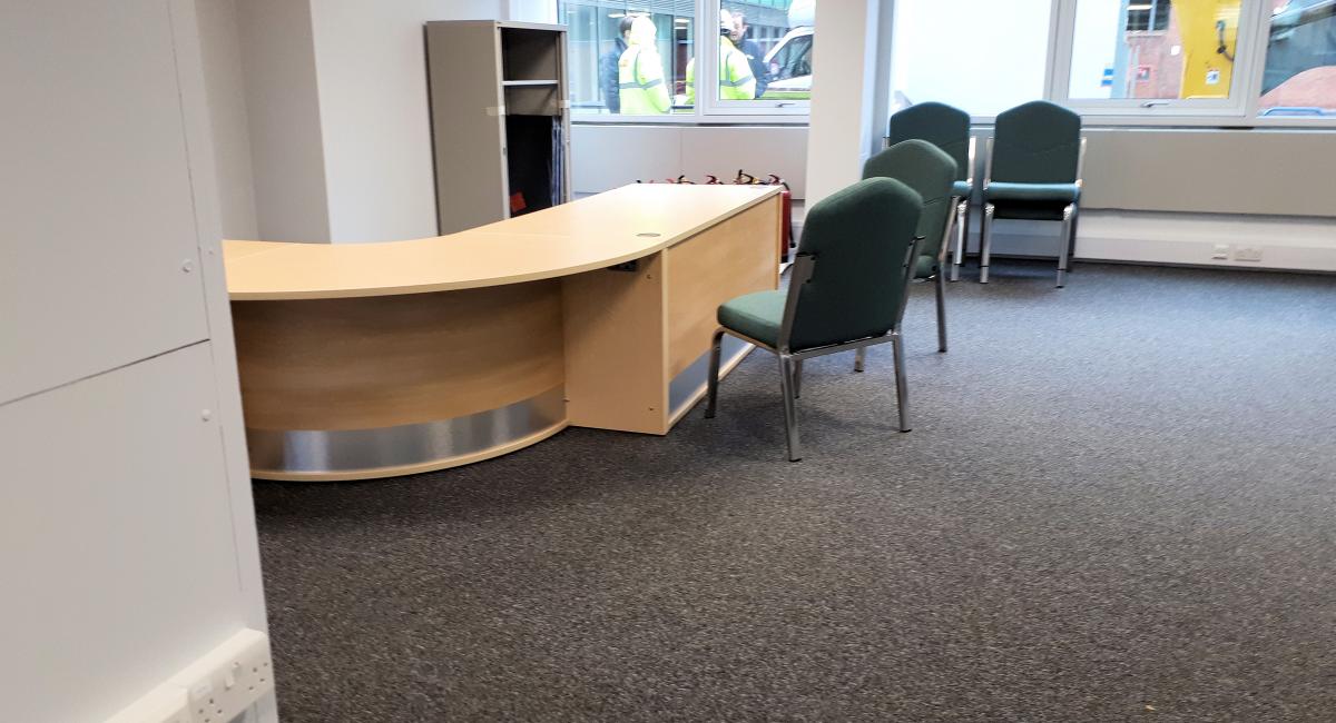 North Hertfordshire District Council  - office move and office furniture refurbishment including reception welcome counter with green upholstered visitor chairs.