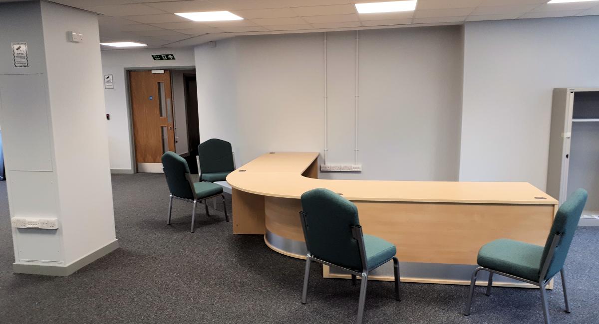 North Hertfordshire District Council  - office move and office furniture refurbishment including reception welcome counter with green upholstered visitor chairs.