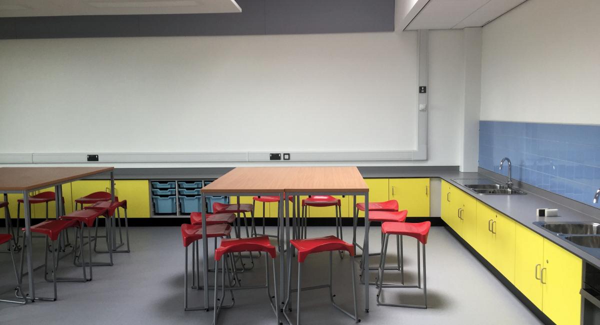 Laboratory standing height tables with red polypropylene topped stools.