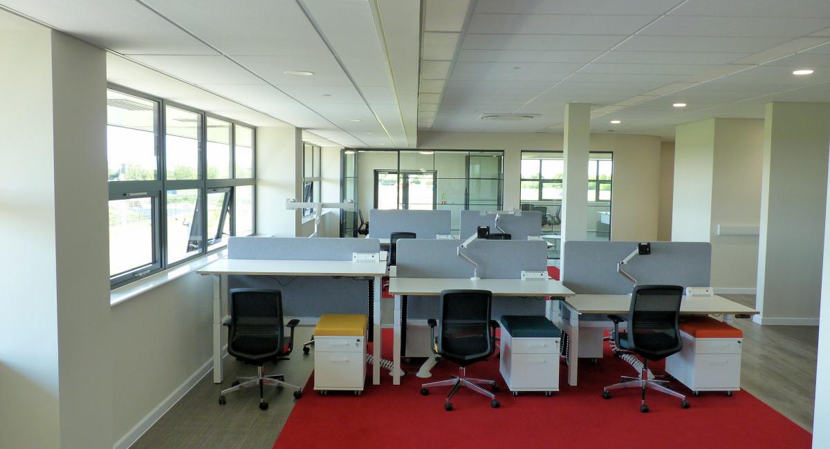 Height adjustable 'sit stand' desks finished in white, partnered with white under-desk personal drawers.