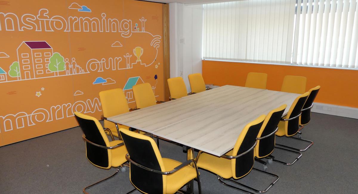 Meeting room table to seat 12 people finished in Nordic Ash with yellow upholstered cantilever frame meeting room chairs.